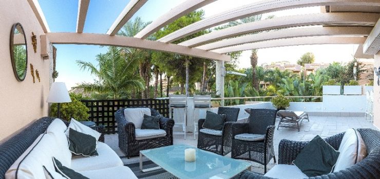 Large, sunny terrace with views to the tropical gardens and the Mediterranean Sea in Marbella, Spain